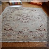 D06. Handknotted beige rug with red accents. Approx. 8'4” x 9'10” 